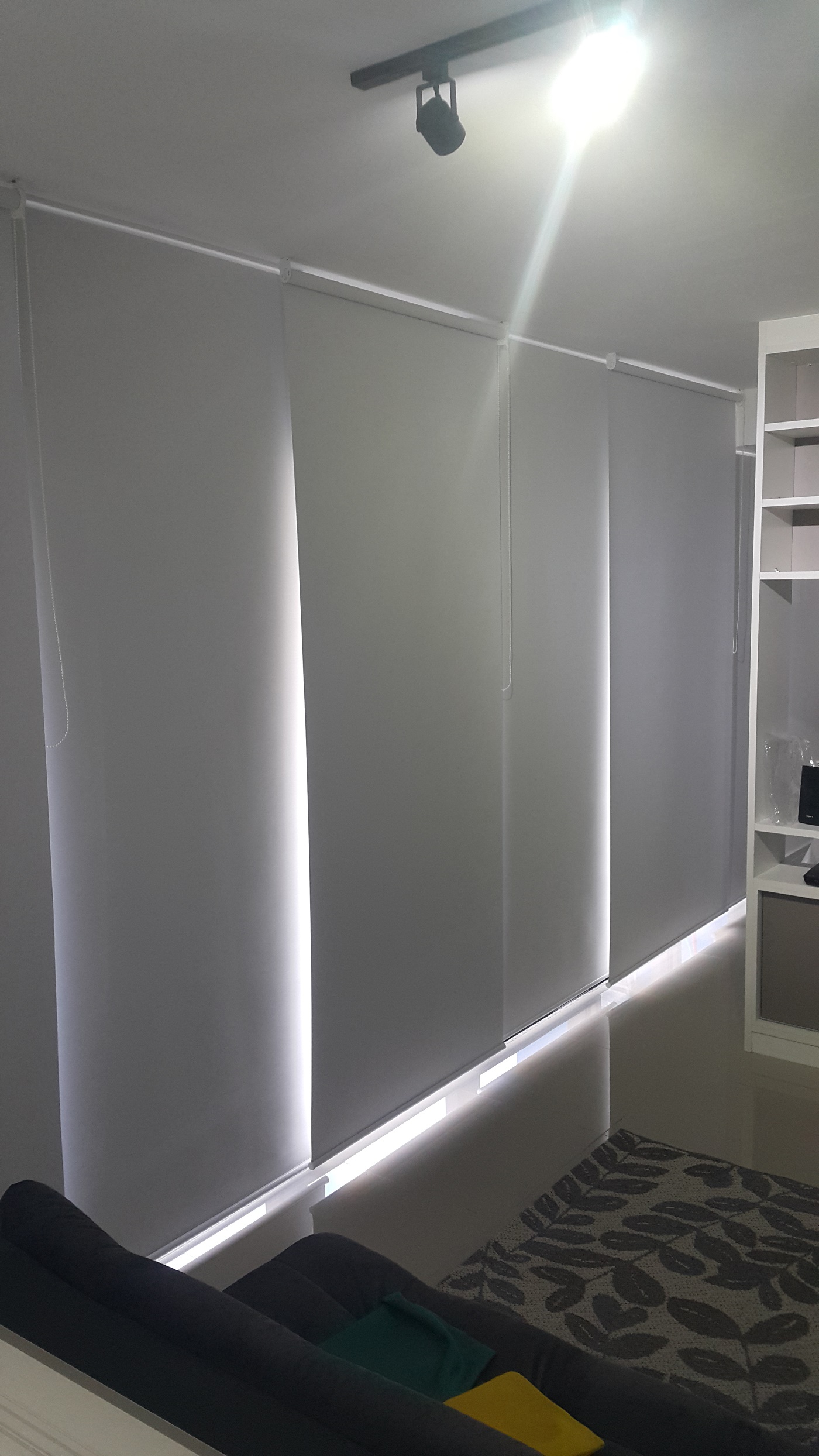 Persianas rolô claras em sacada com vista para a praia